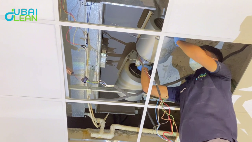 Technician cleaning dusty AC coil with specialized tools to improve cooling performance