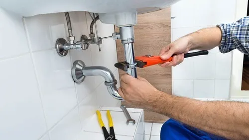 Professional plumber installing pipes in Dubai home - plumbing services