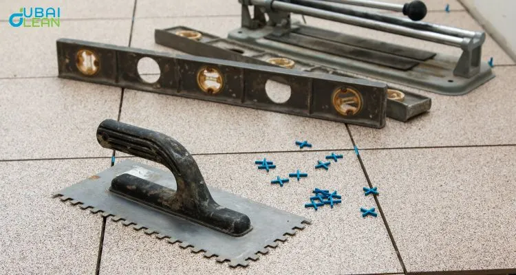 Professional technician performing tile floor installation and fixing with precision tools in Dubai.

