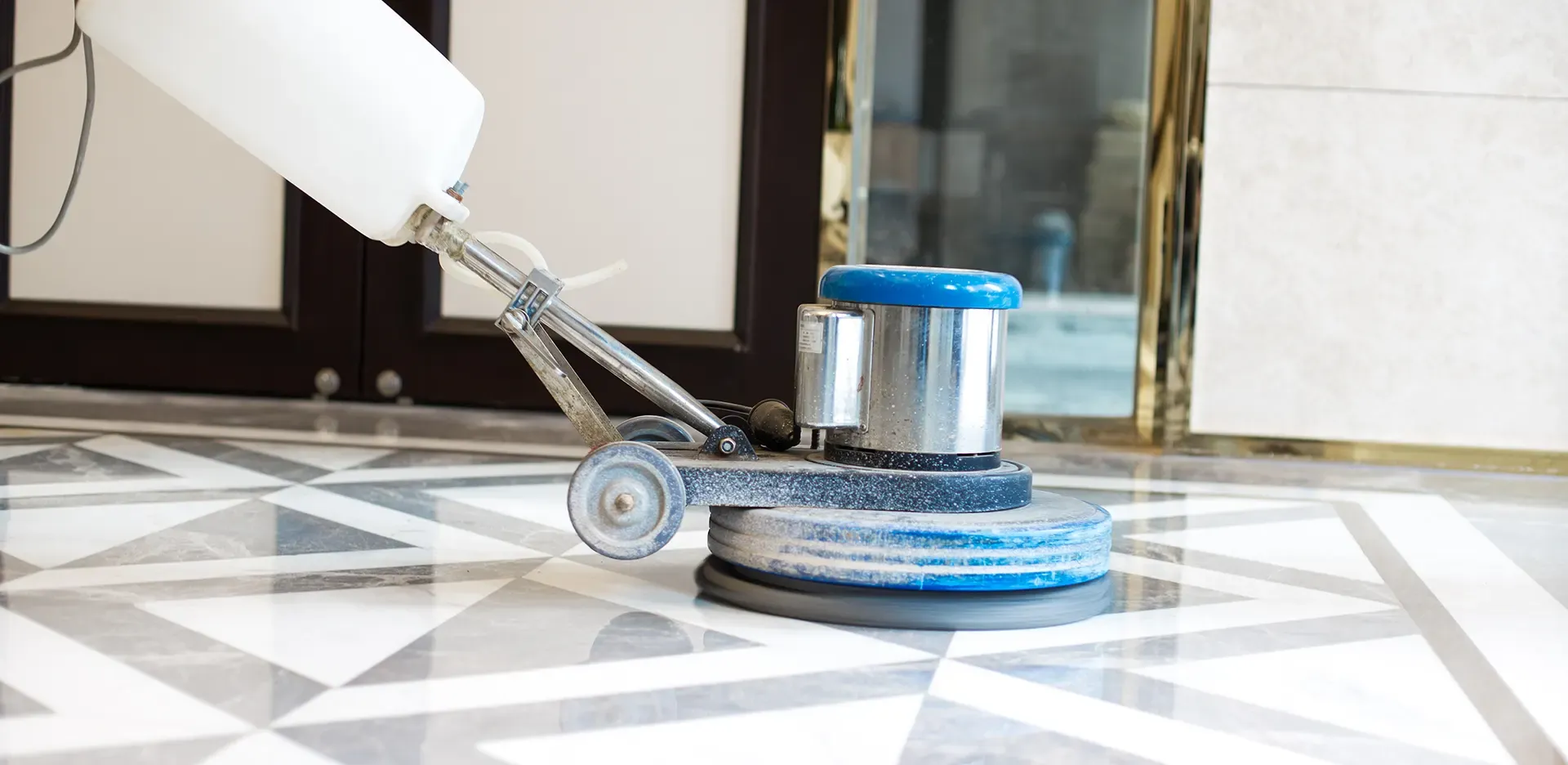 Technician performing marble polishing and crystallisation on a glossy white floor