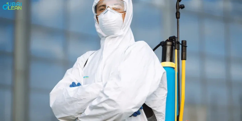 Pest control professional in protective attire applying a non‑toxic spray along the edges of a contemporary living room floor.